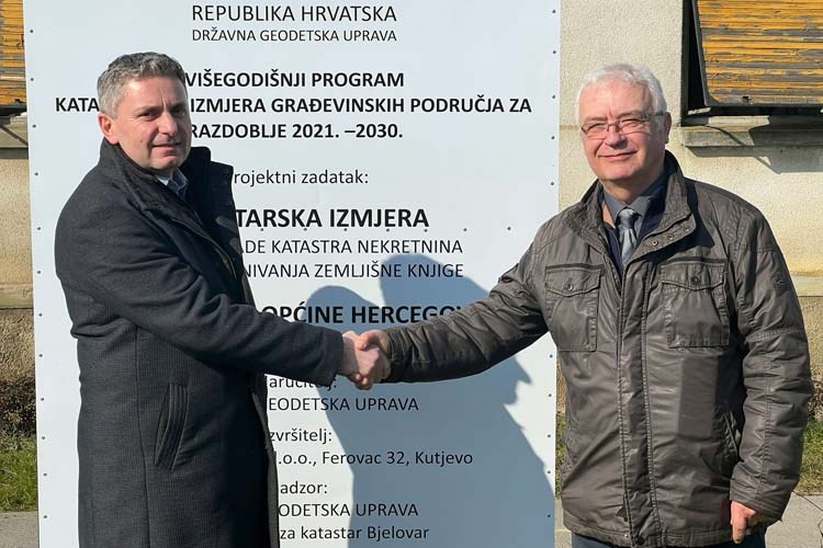 Slika Pročelnik Soptija rukuje se s načelnikom općine Hercegovac ispred ploče kojom se otvara izmjera